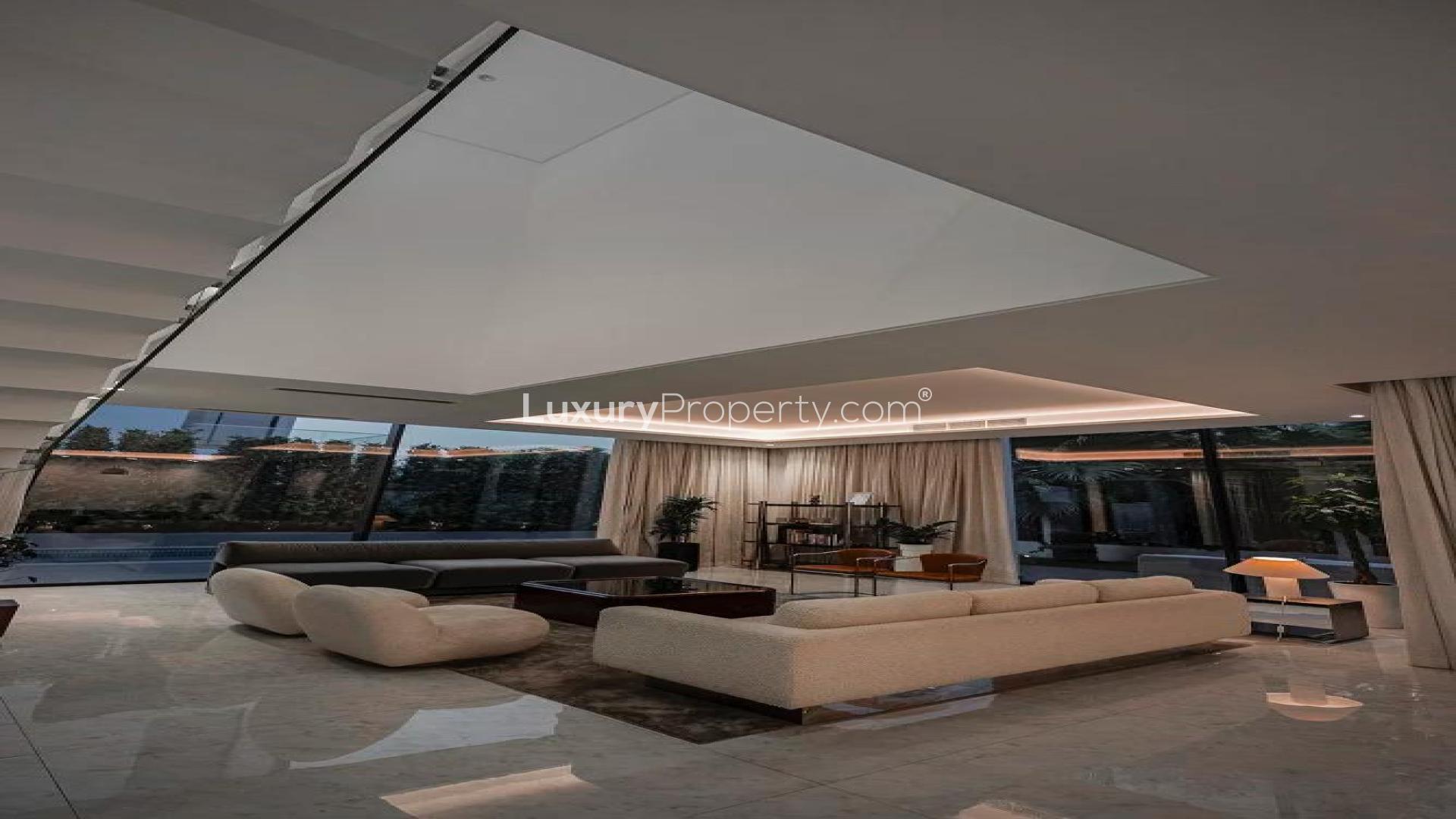 Luxurious Al Barari villa patio with modern furniture and large glass doors at dusk