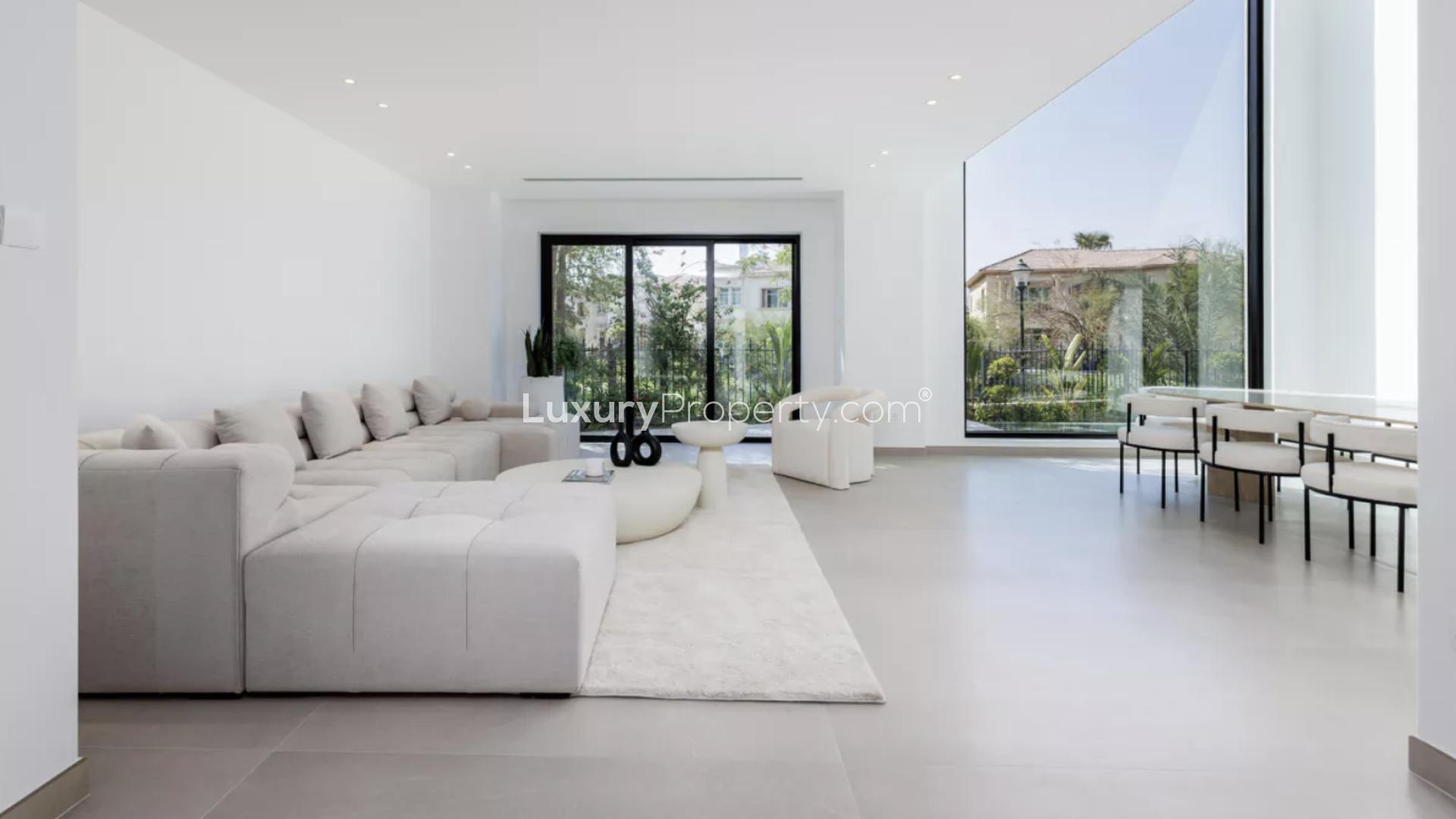 Luxurious dining area with large windows overlooking garden and pool in Jumeirah Islands villa