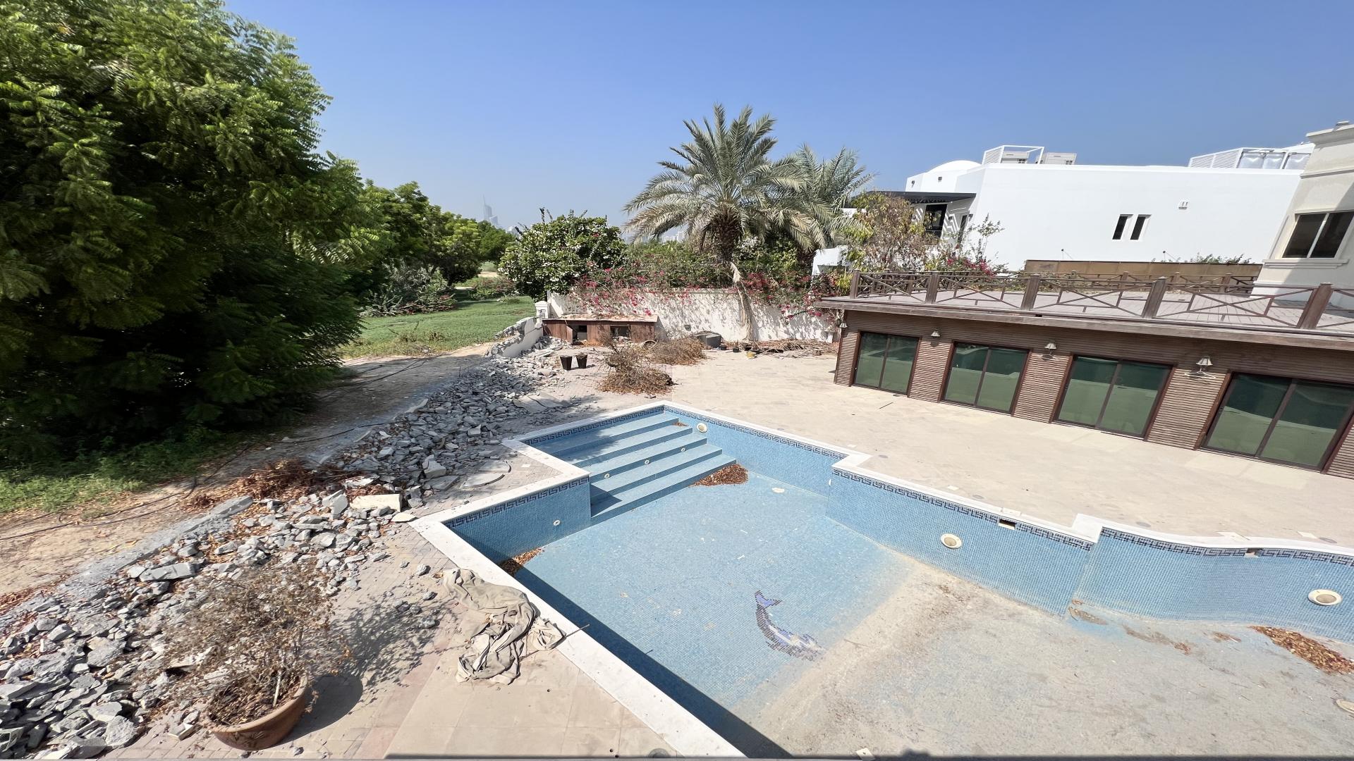 Outdoor view of luxury villa with empty pool in Emirates Hills, Sector R