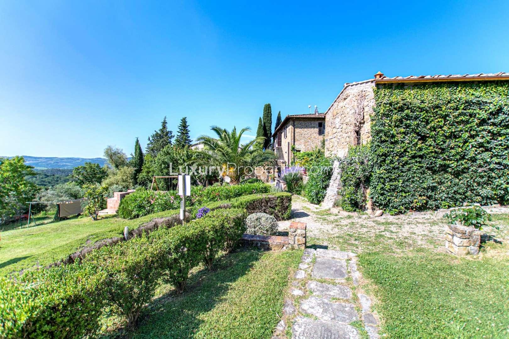 Charming garden view at classical Chianti villa, Florence, featuring stone walls and greenery