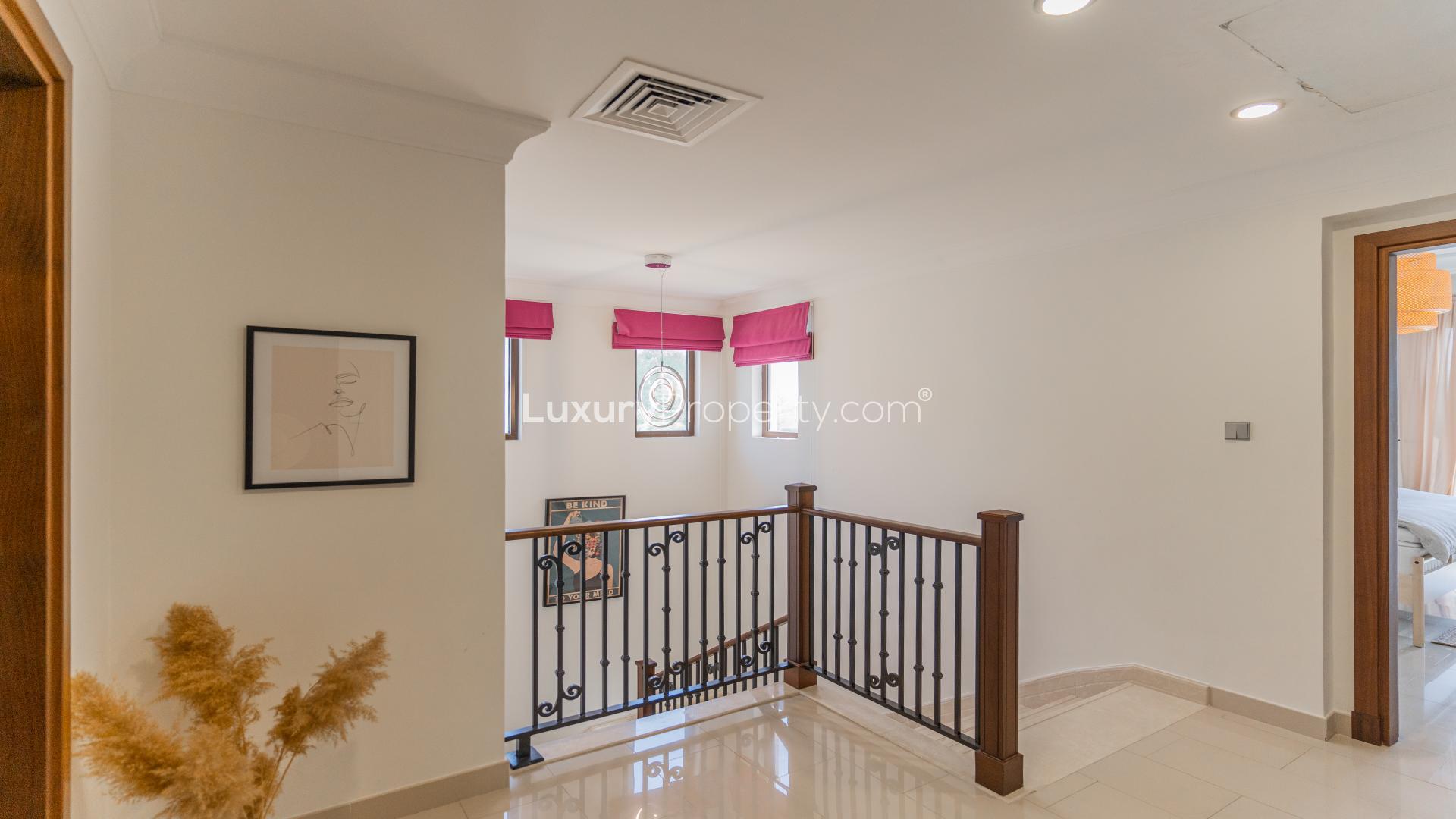 "View of luxurious villas in Aseel, Arabian Ranches, surrounded by lush greenery and streets.",Interior hallway of premium 5-bedroom villa in Aseel, Arabian Ranches, with modern decor