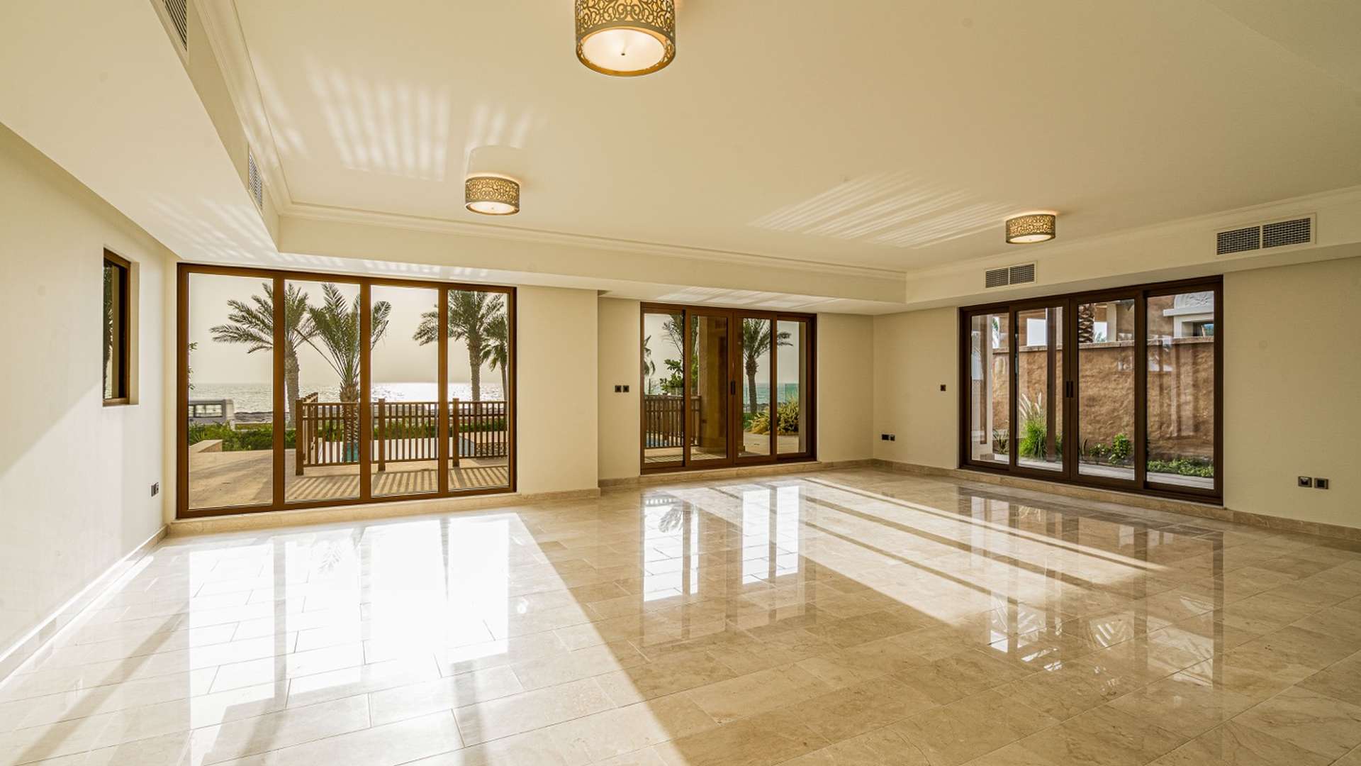 Empty room with sea view through glass doors in Palm Jumeirah villa for sale