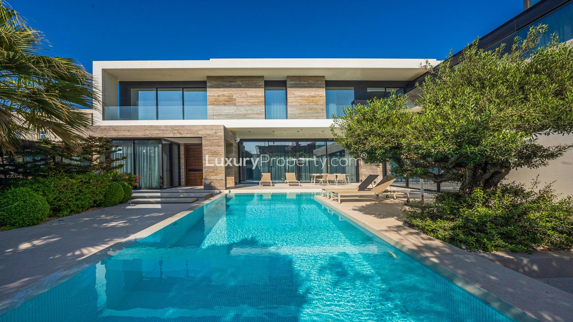 Pearl Jumeirah villa exterior with pool, modern architecture, lush greenery, for sale