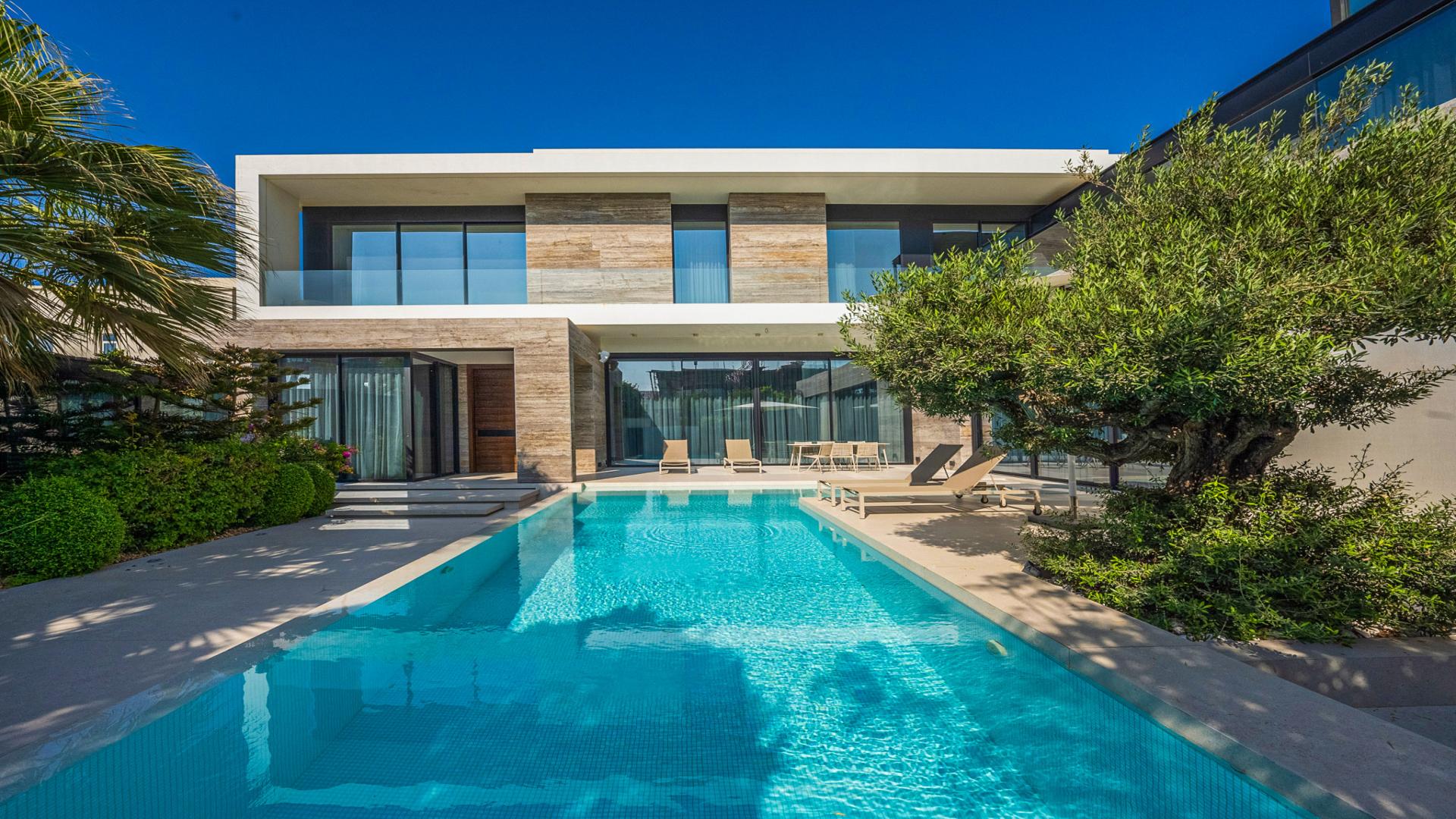 Pearl Jumeirah villa exterior with pool, modern architecture, lush greenery, for sale