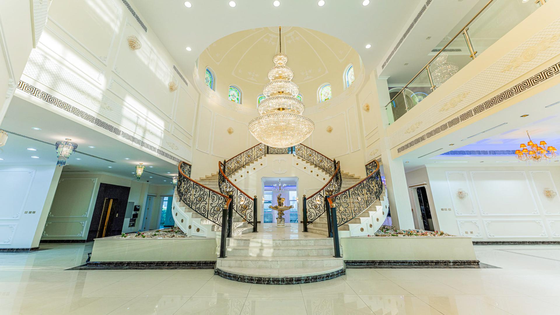 Luxurious Pearl Jumeirah villa exterior at night, featuring elegant architecture and palm trees