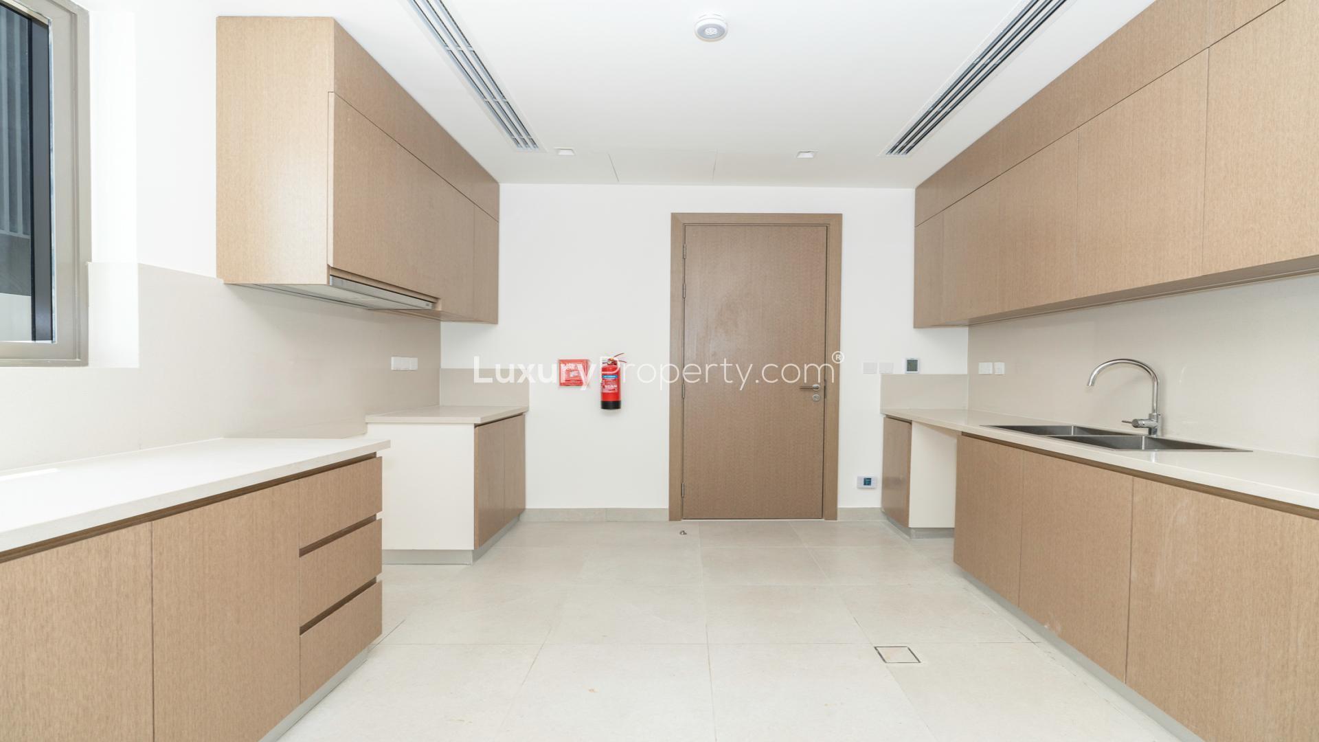 Modern kitchen in Tilal Al Furjan villa with large windows and sleek design