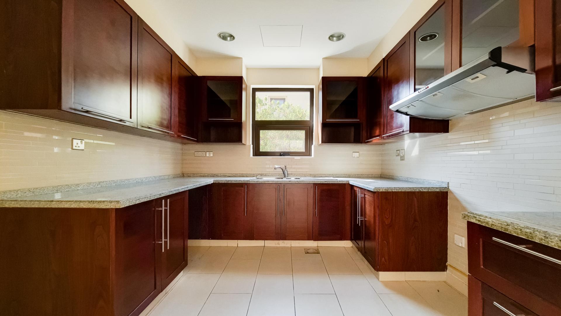 "Spacious courtyard in Type 6 villa, Casa, Arabian Ranches 2, lush greenery, for sale.",Modern kitchen with wooden cabinets in Arabian Ranches 2 villa, Casa sub-community