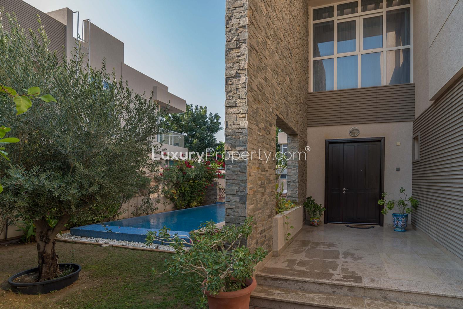 "Elegant entrance and pool area of 4-bedroom villa in Cedre Villas, Dubai Silicon Oasis.",Elegant entrance of Cedre Villas 5-bedroom villa with private garden and pool, Dubai Silicon Oasis
