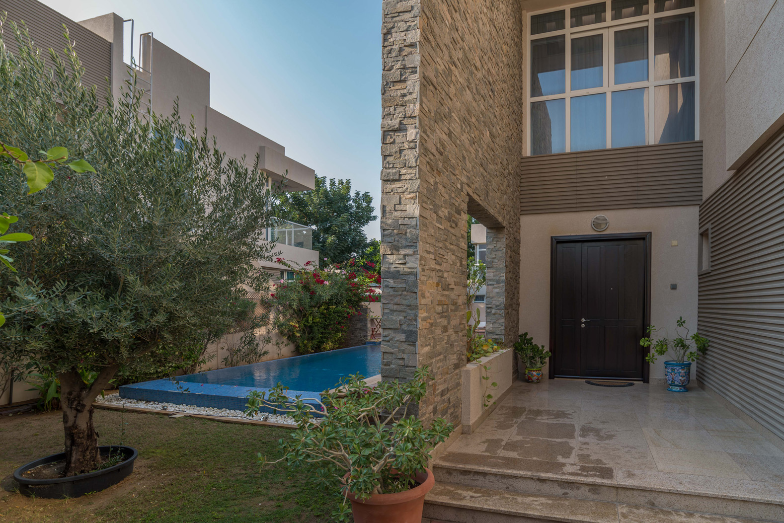 "Elegant entrance and pool area of 4-bedroom villa in Cedre Villas, Dubai Silicon Oasis.",Elegant entrance of Cedre Villas 5-bedroom villa with private garden and pool, Dubai Silicon Oasis