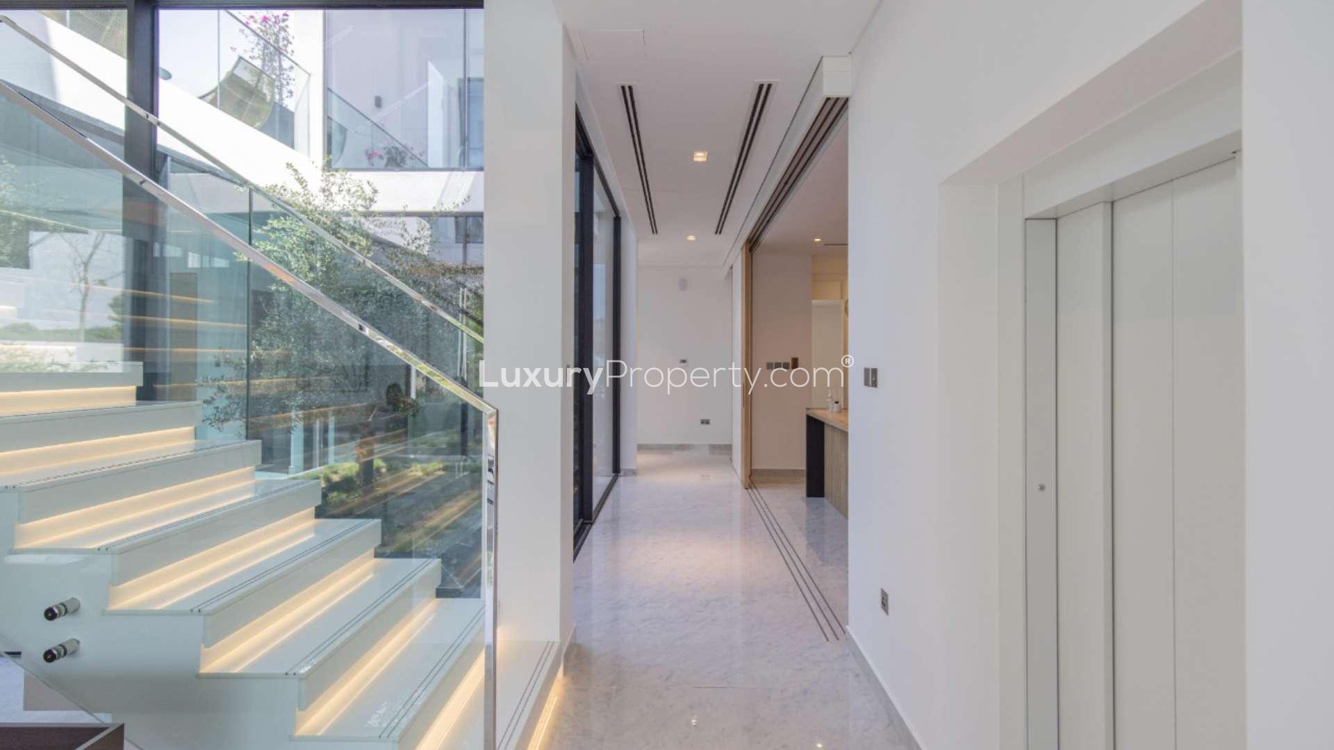 "Modern staircase and hallway in luxury Al Barari Chorisia 1 Villa for sale.",Modern interior of new 5-bedroom villa in Al Barari with pool view