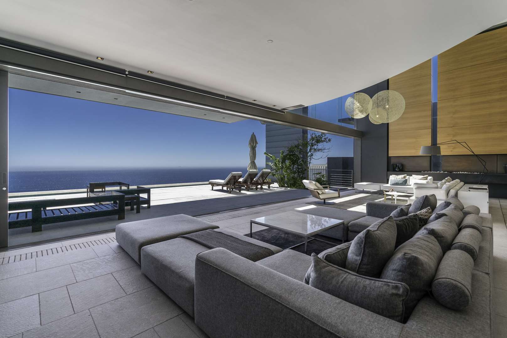 Luxurious Clifton villa living room with ocean view, modern design, and outdoor lounge area