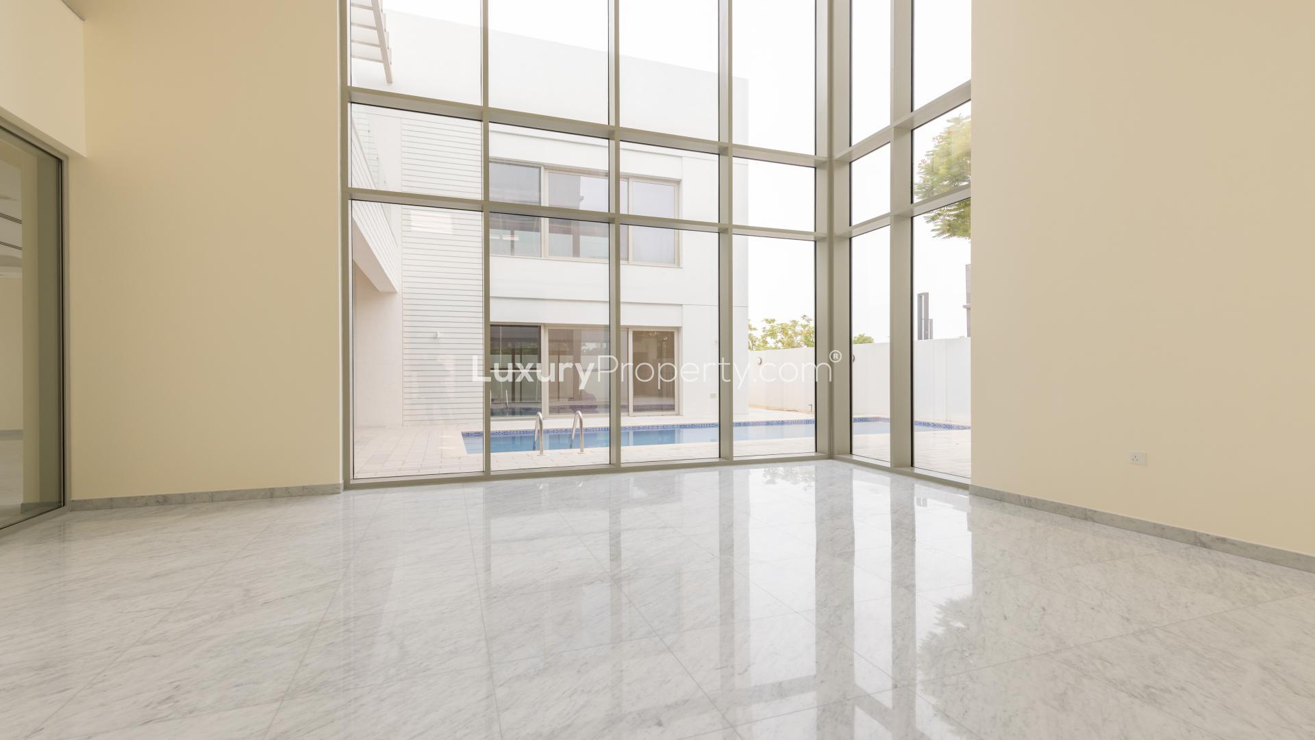 "Spacious villa interior with large windows overlooking pool in District One, MBR City.",Spacious open-plan living area with large windows in District One villa, Mohammed Bin Rashid City