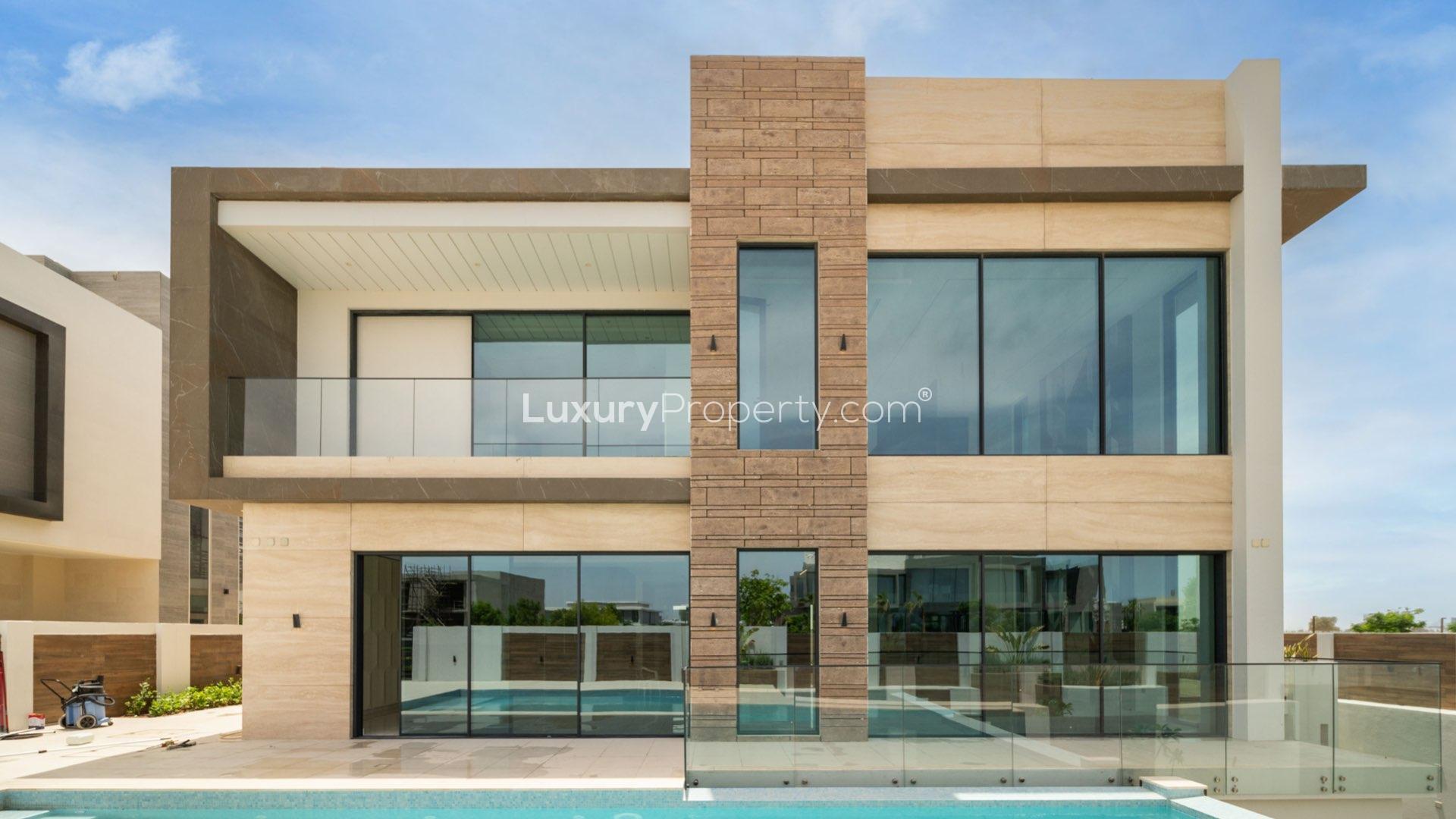 Modern villa with illuminated pool at night, Dubai Hills Estate, available for sale