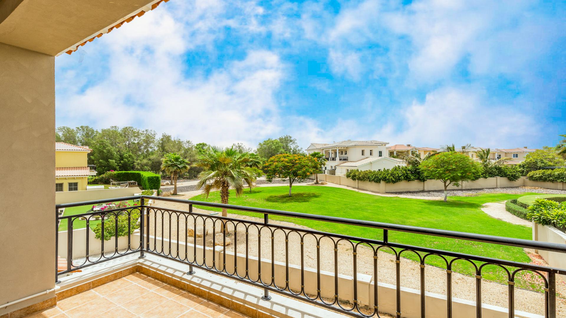 "Elegant 5-bedroom villa with landscaped garden in Jumeirah Golf Estates, Earth community for sale.",Balcony view of landscaped garden at spacious villa in Jumeirah Golf Estates, Earth community