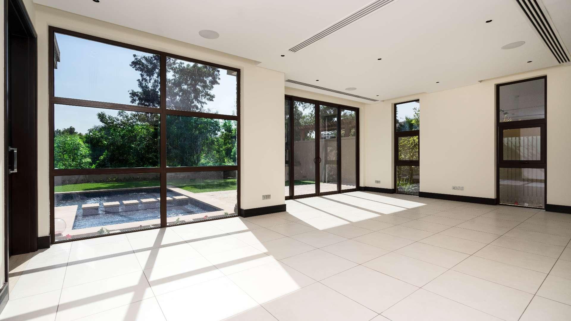 Spacious villa interior with large windows and garden view in Jumeirah Golf Estates