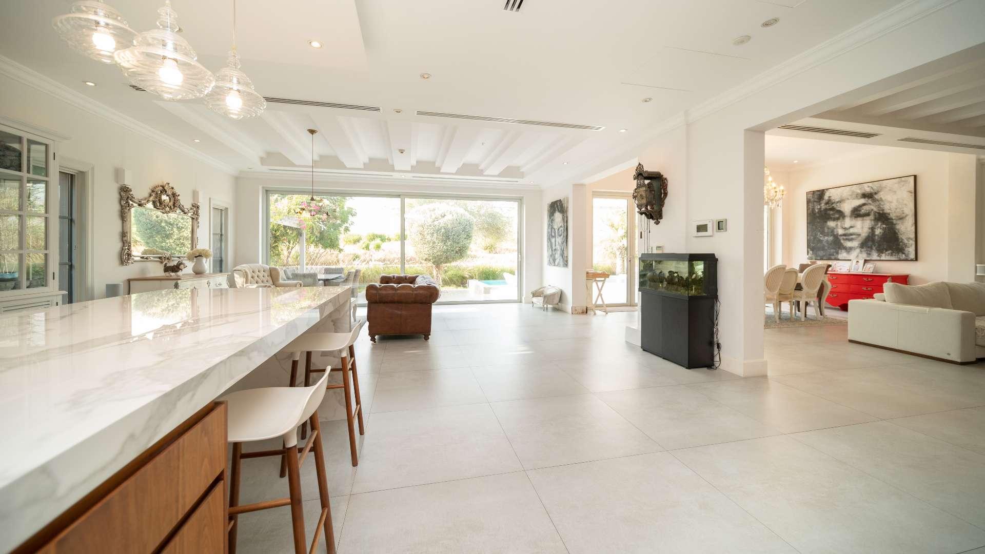 Modern kitchen in upgraded Jumeirah Golf Estates villa with sleek wood cabinetry and island