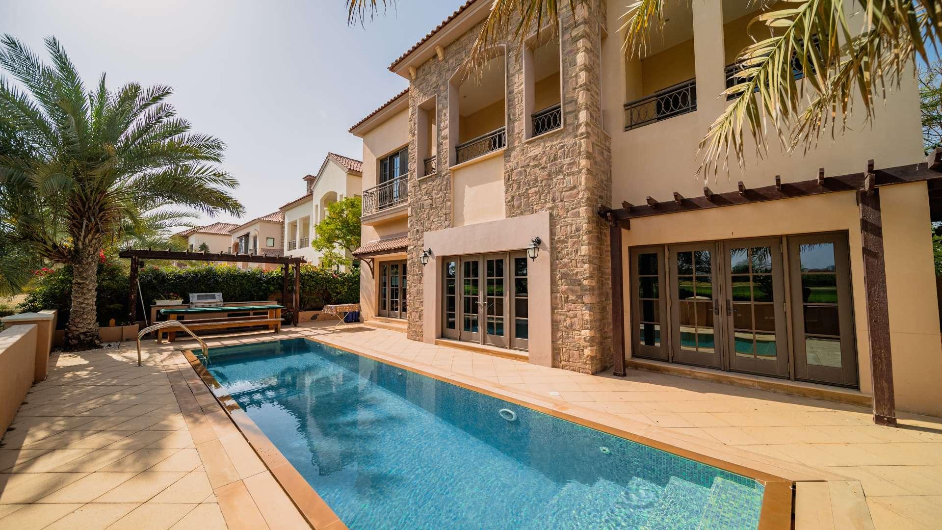 Beautiful villa pool with palm trees and golf course views in Jumeirah Golf Estates