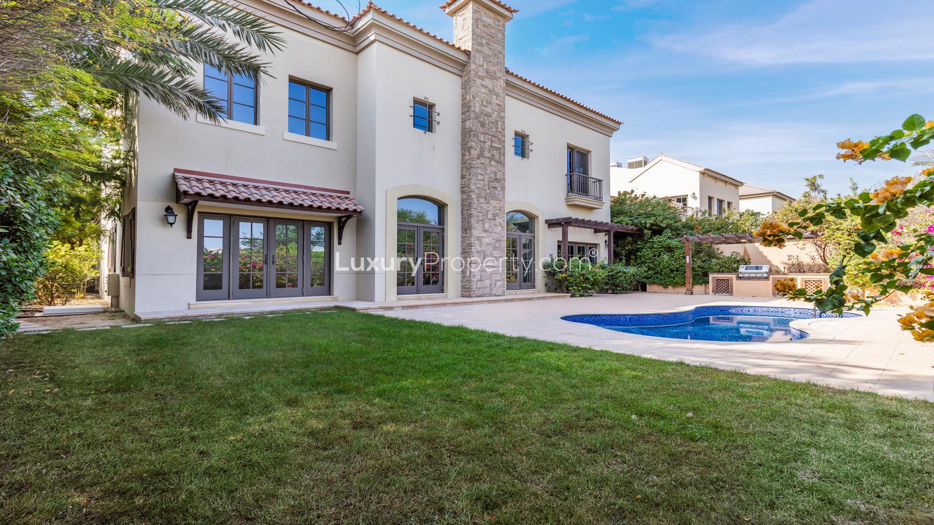 Spacious living room with fireplace in Jumeirah Golf Estates villa for sale