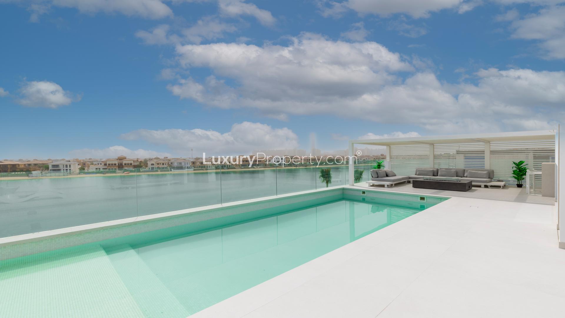 Luxurious poolside lounge area in Palm Jumeirah villa, featuring modern design and seating