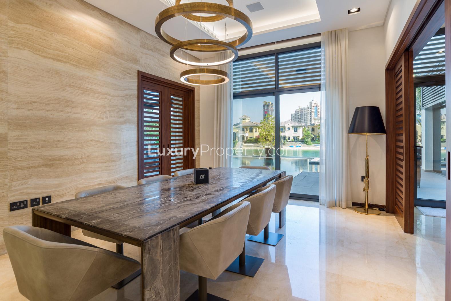 Modern dining room in luxury villa, Palm Jumeirah, overlooking pool and garden view