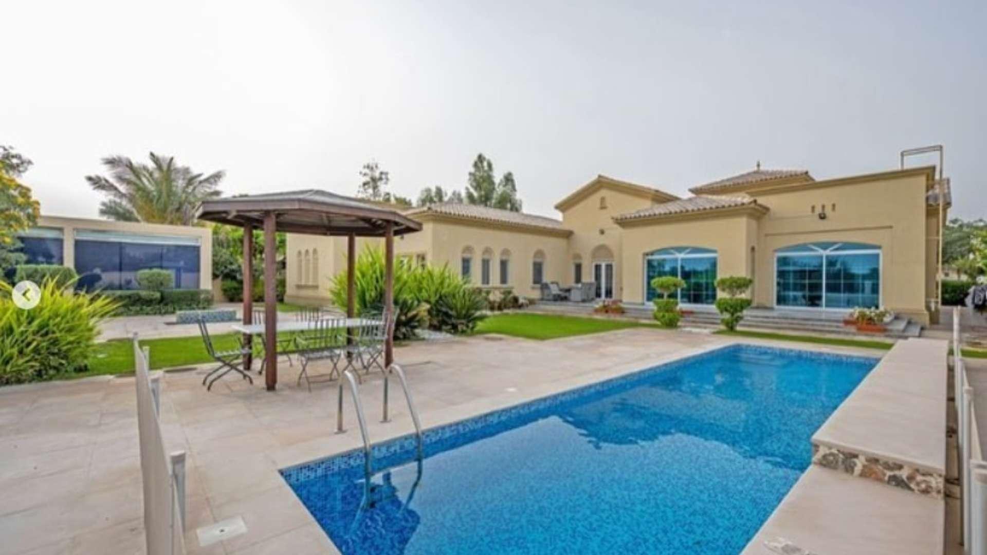 Aerial view of luxurious 5-bedroom villa with pool and golf course in Arabian Ranches