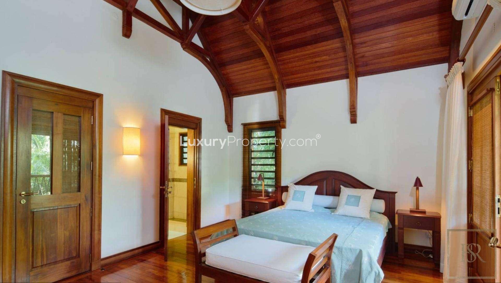 Beachfront villa balcony view with ocean, palm trees, and lounge chairs in Grand Bay, Mauritius