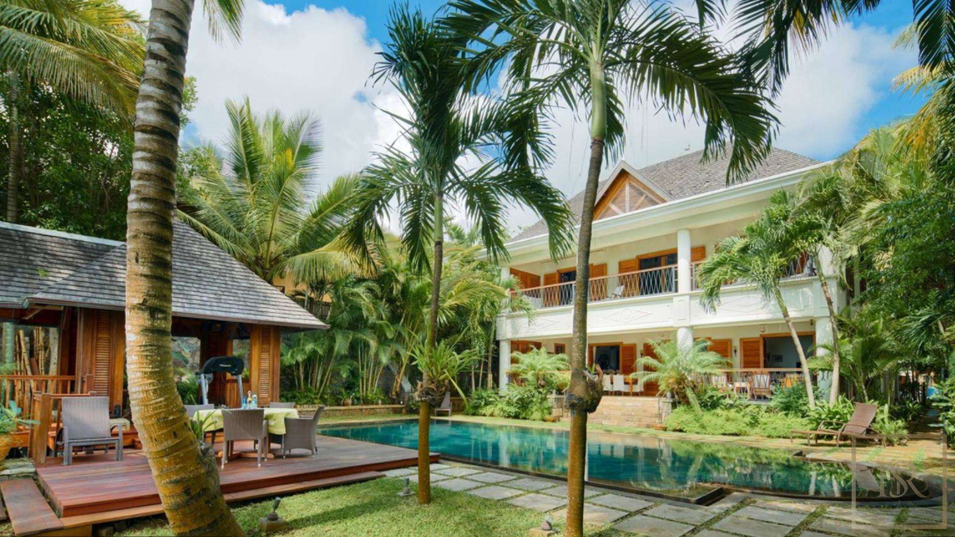 Luxurious bedroom in beachfront villa, Grand Bay, North Mauritius, with wooden ceiling and decor