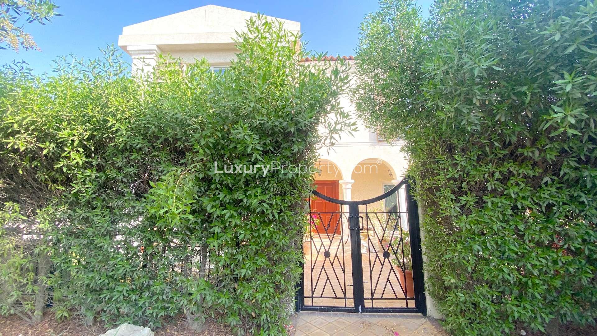 Elegant villa entrance with lush greenery in Green Community West, available for sale