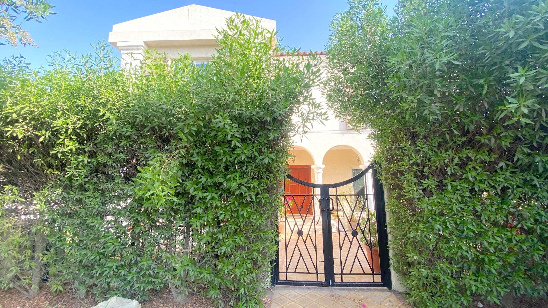 Elegant villa entrance with lush greenery in Green Community West, available for sale