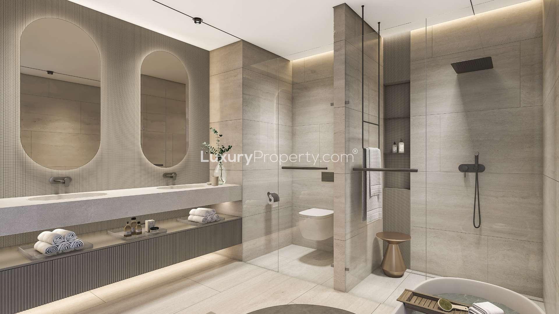 "Modern 5-bedroom villa with pool, terrace, and garden in Tilal Al Ghaf for sale.",Modern bathroom in Tilal Al Ghaf villa, featuring dual sinks and spacious shower area