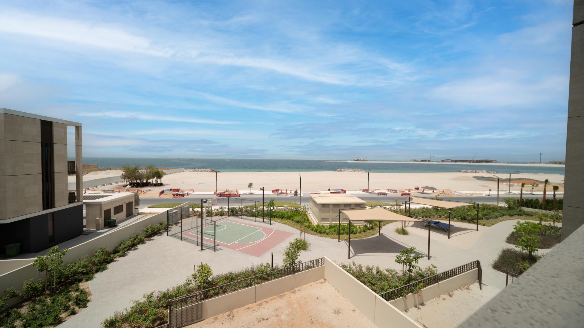 Modern kitchen in five-bed villa on Jumeirah Bay Island, featuring wood cabinets and stone countertops
