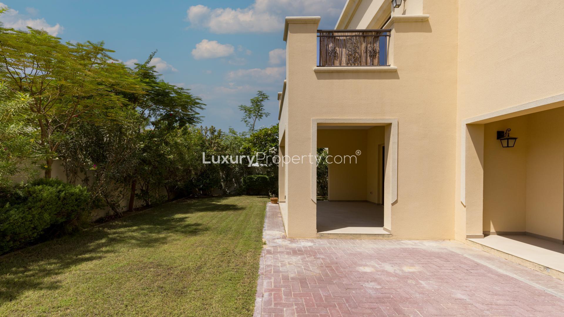"Spacious living area in 5-bedroom villa, Arabian Ranches 2, with garden view through glass doors.",Corner plot villa with mature garden in Arabian Ranches 2, Lila community