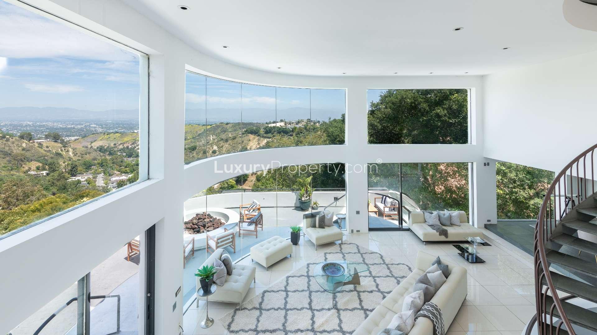 Spacious living area with panoramic views, modern furniture, and spiral staircase in Bel Air Villa
