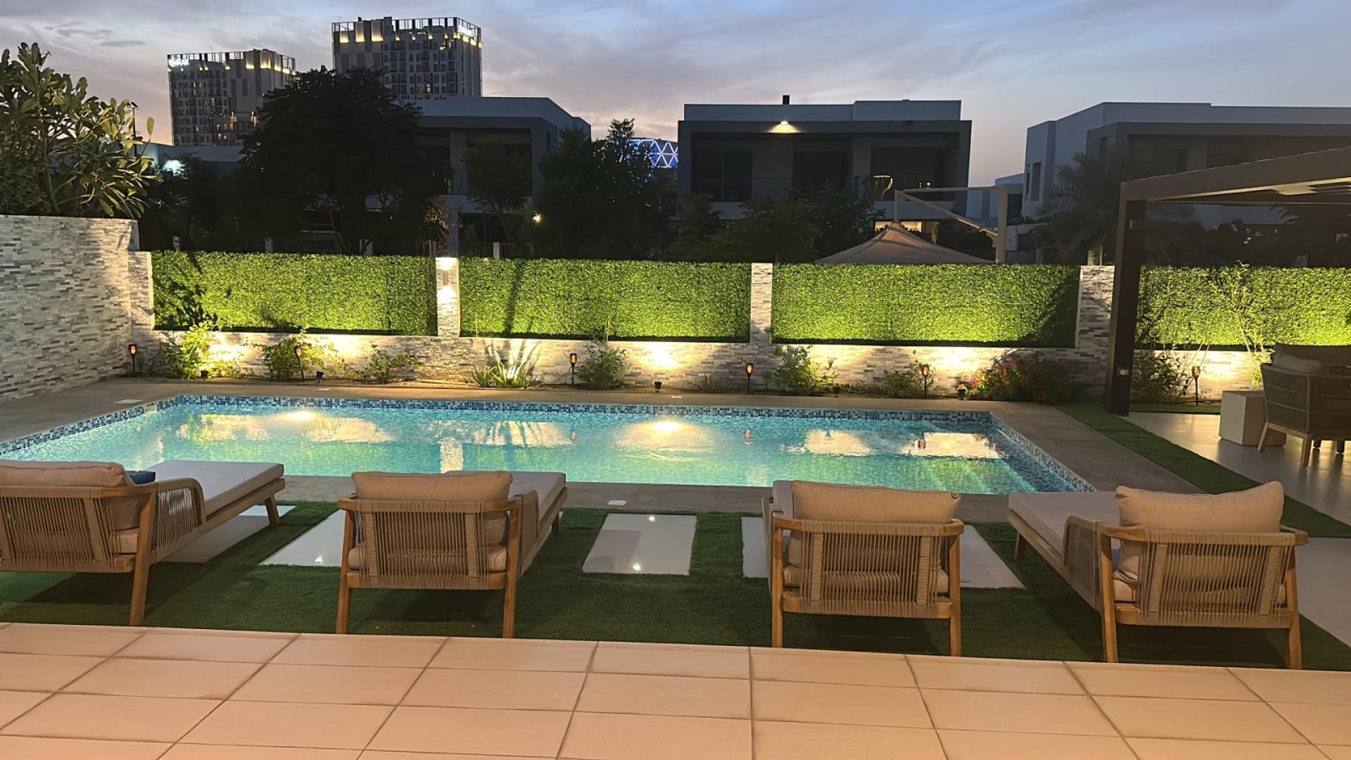 "Spacious interior of modern villa in Sidra Villas, Dubai Hills Estate, with large windows.",Luxurious poolside view at modern villa in Sidra Villas, Dubai Hills Estate