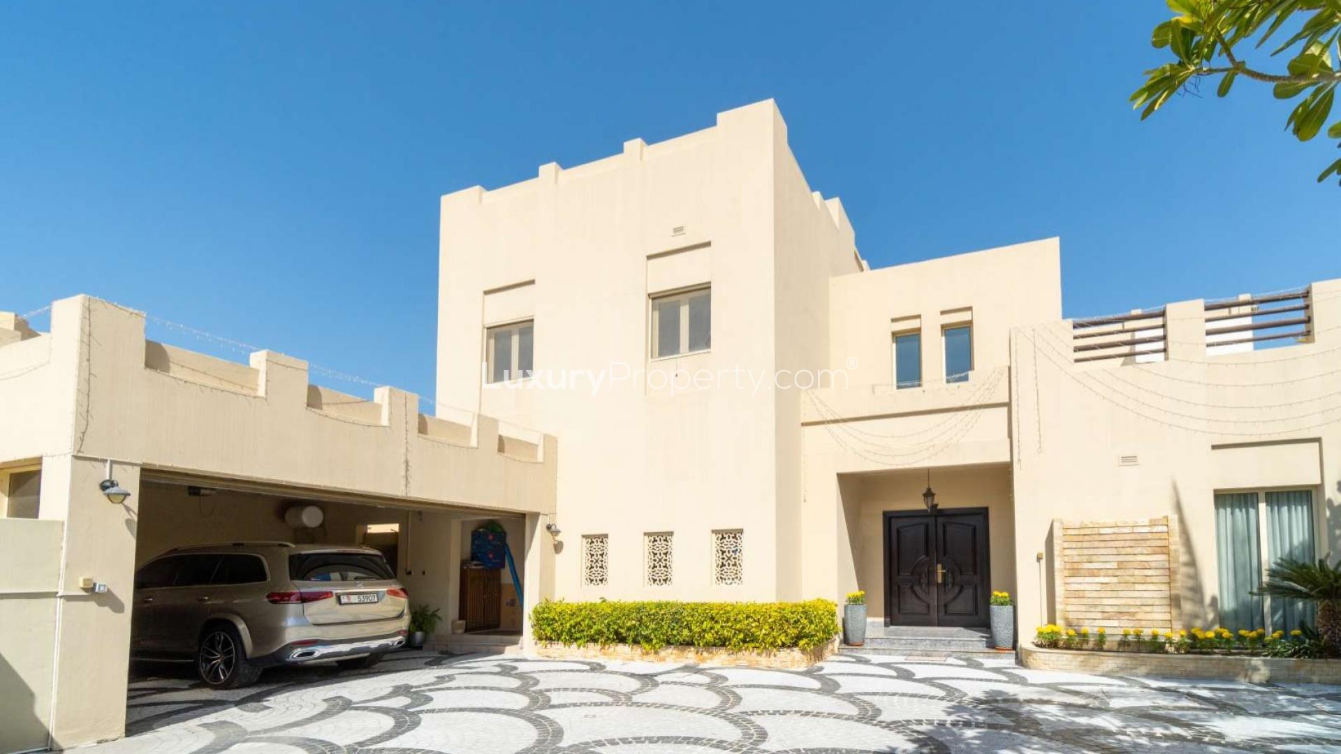 Luxurious walk-in closet in Meadows 5 villa with wooden cabinetry and mirrored doors