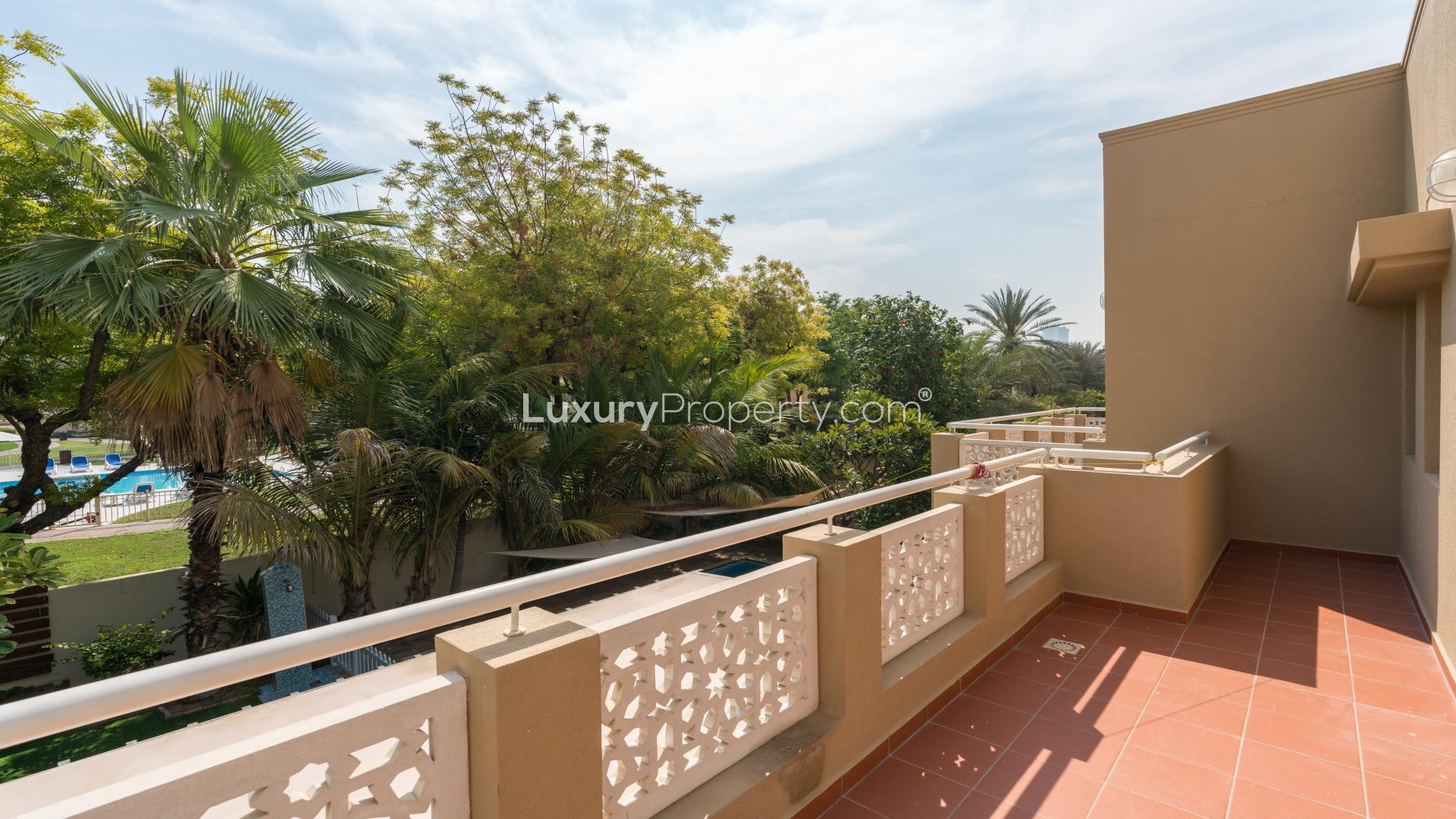 Spacious balcony view of lush garden and pool in Meadows villa, Emirates Living