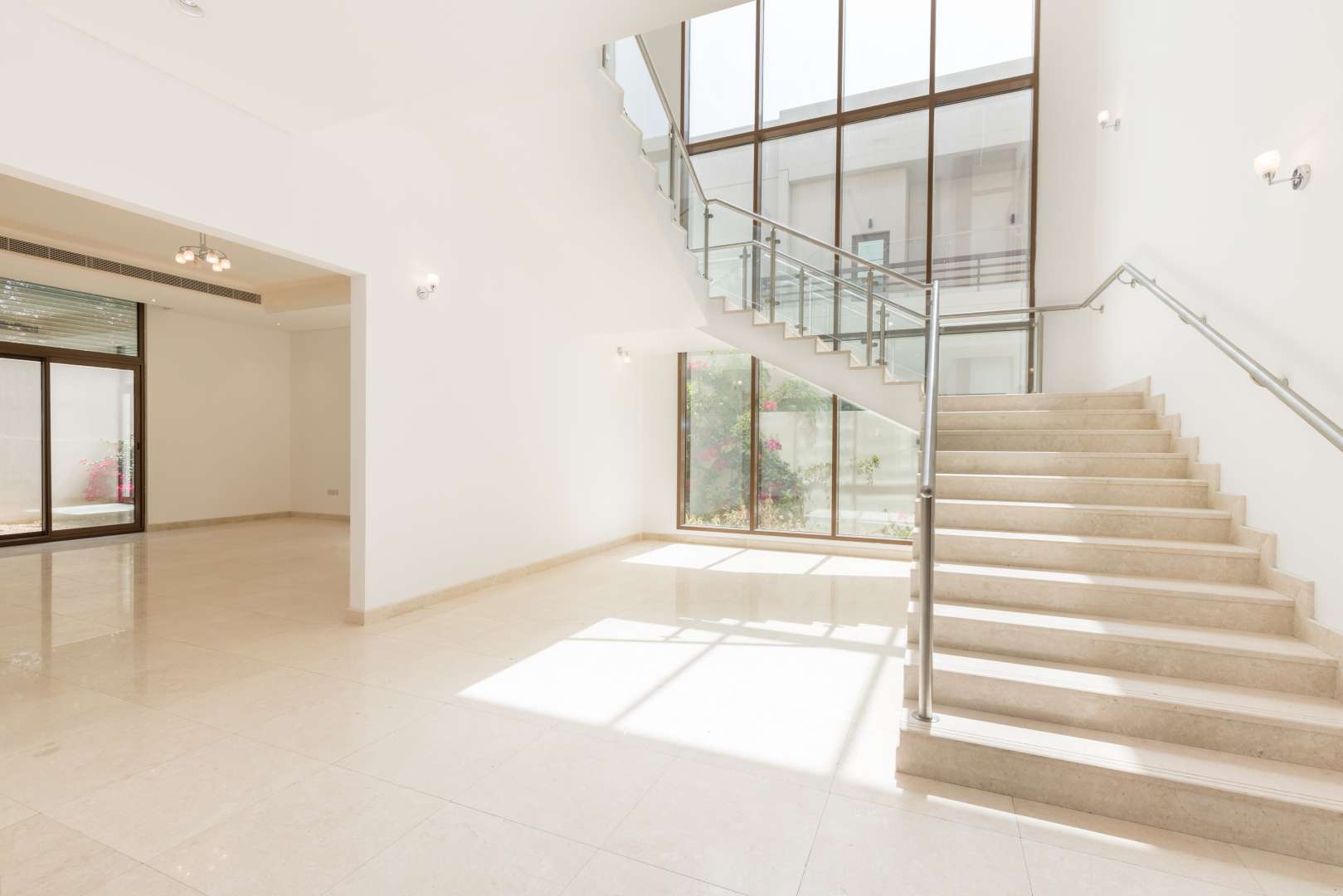 Bright staircase with glass railing in Meydan five-bedroom villa for sale