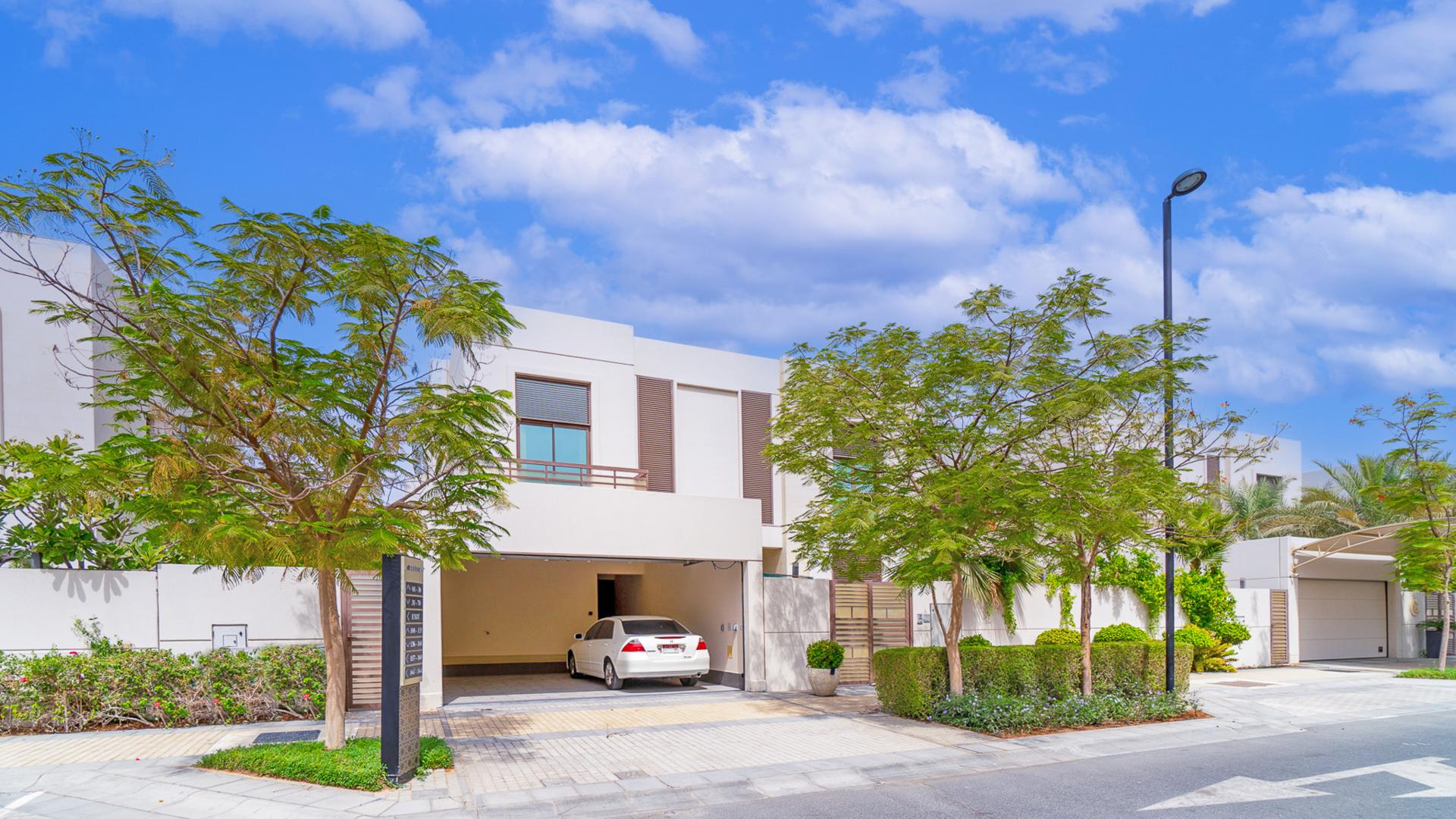 Luxury villa exterior in Meydan Gated Community with lush greenery and modern design