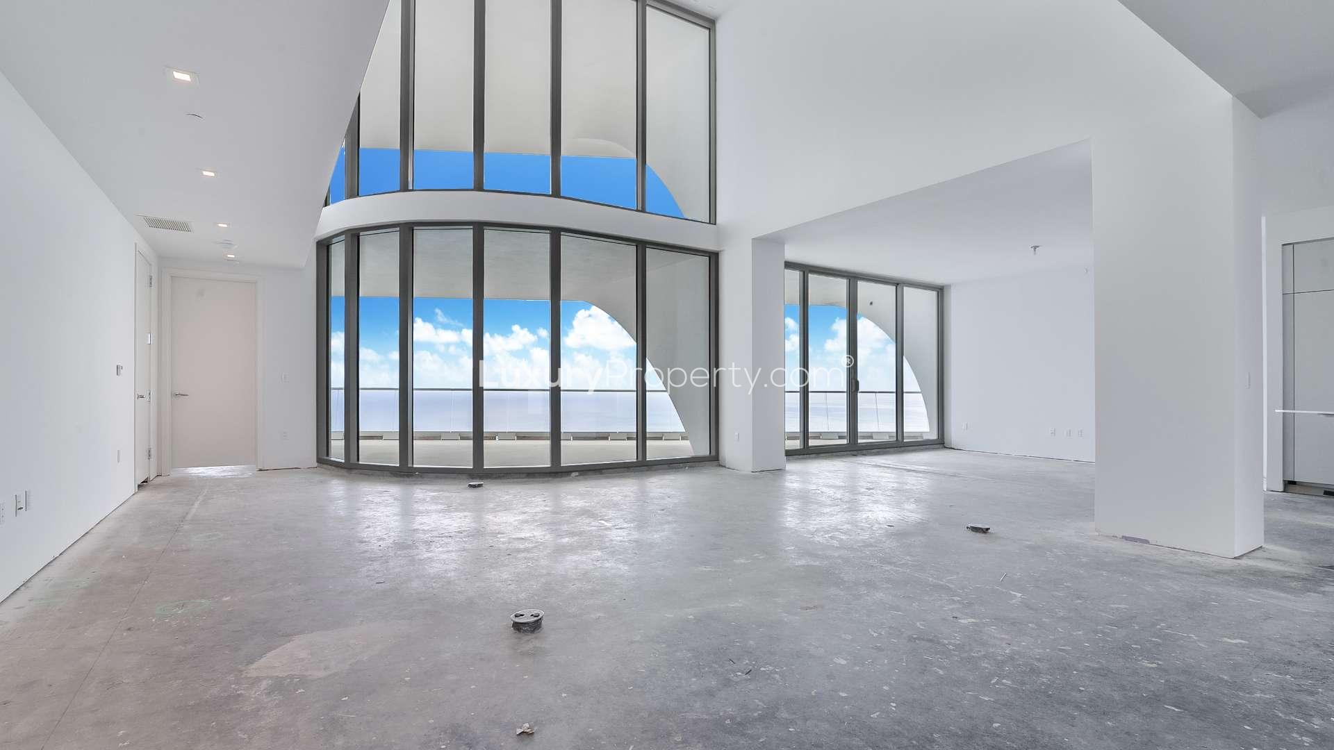 "Spacious balcony with ocean view in Miami villa for sale, five-bedroom home.",Spacious living room with floor-to-ceiling windows in Miami villa for sale, LP10451