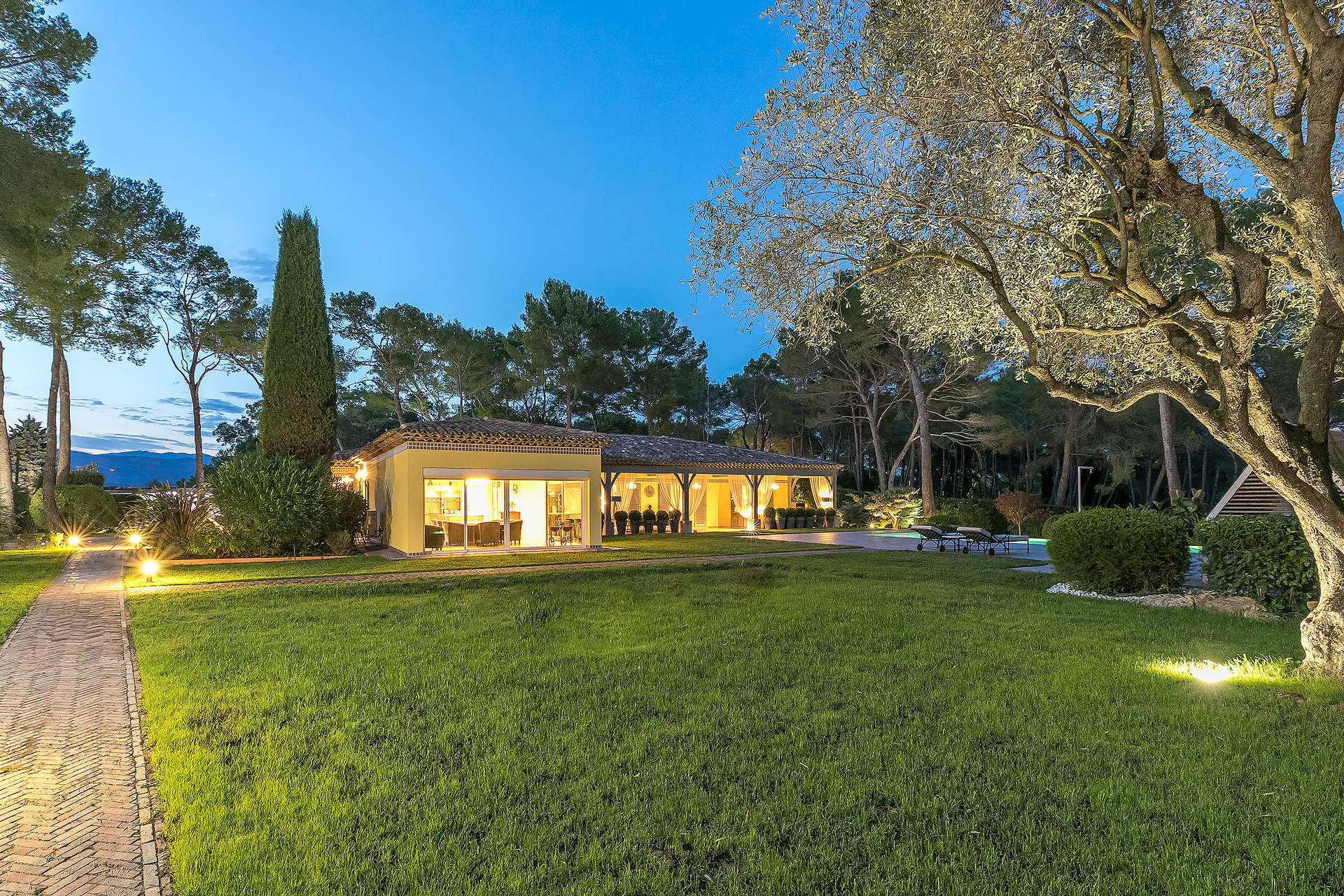 Luxurious villa exterior at night in Mougins, French Riviera, with illuminated pathway