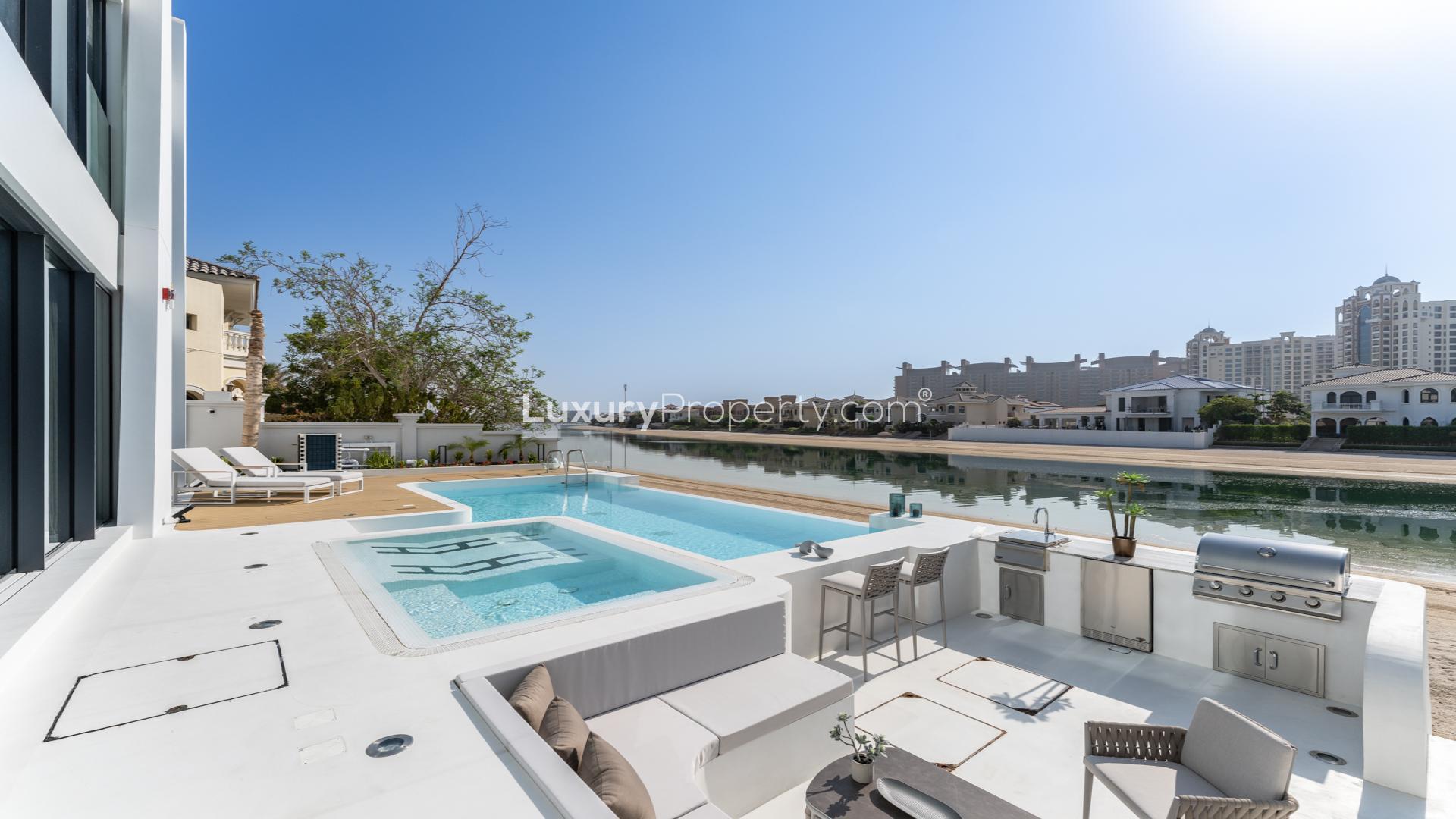 "Modern 5-bed villa exterior with palm trees, Garden Homes, Palm Jumeirah, for sale.",Luxurious villa with private pool and outdoor kitchen in Palm Jumeirah, Garden Homes