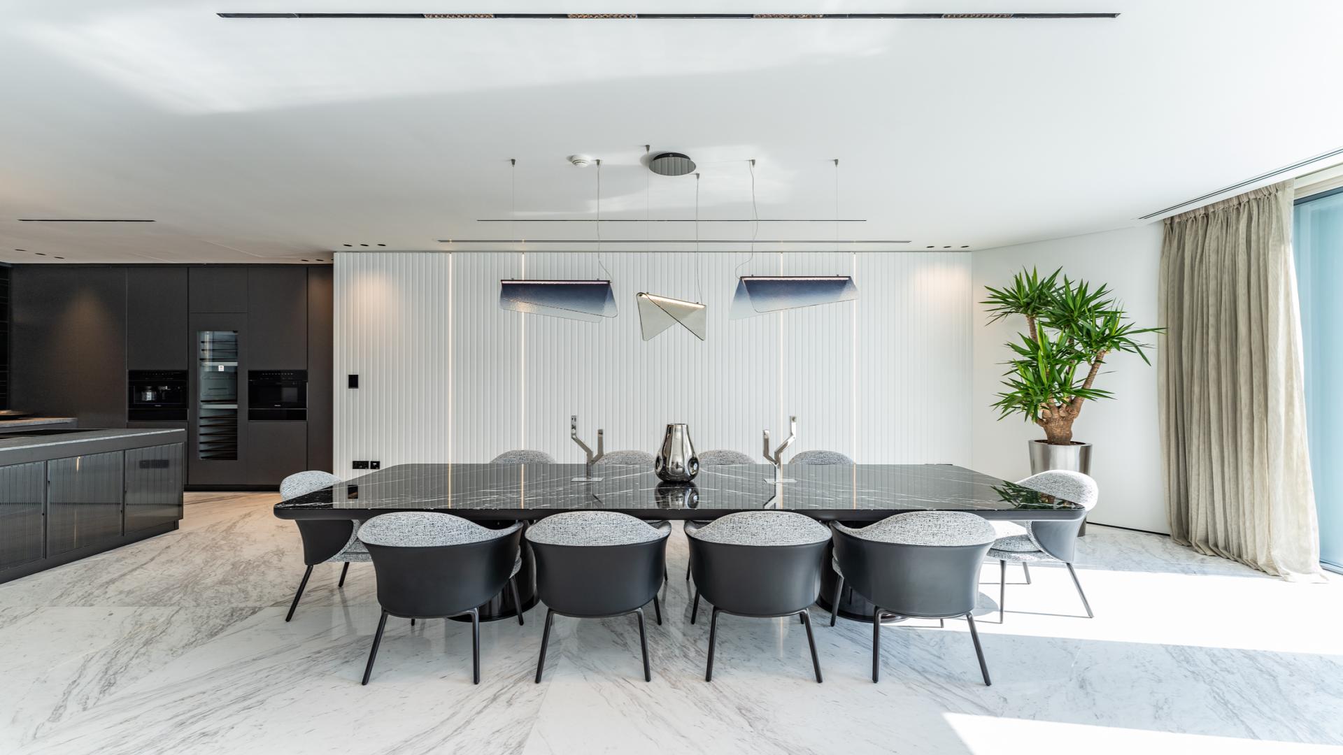 Luxury dining area with sleek black table in Palm Jumeirah villa, Garden Homes