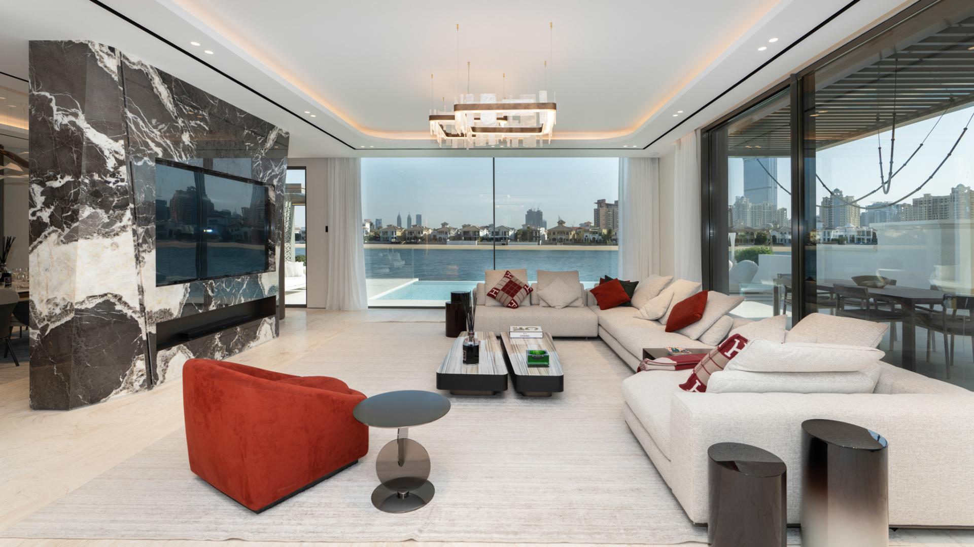 "Stunning Palm Jumeirah villa exterior with pool, modern design, and luxurious seating area.",Luxurious Palm Jumeirah villa living room with stunning waterfront views, modern decor, spacious layout