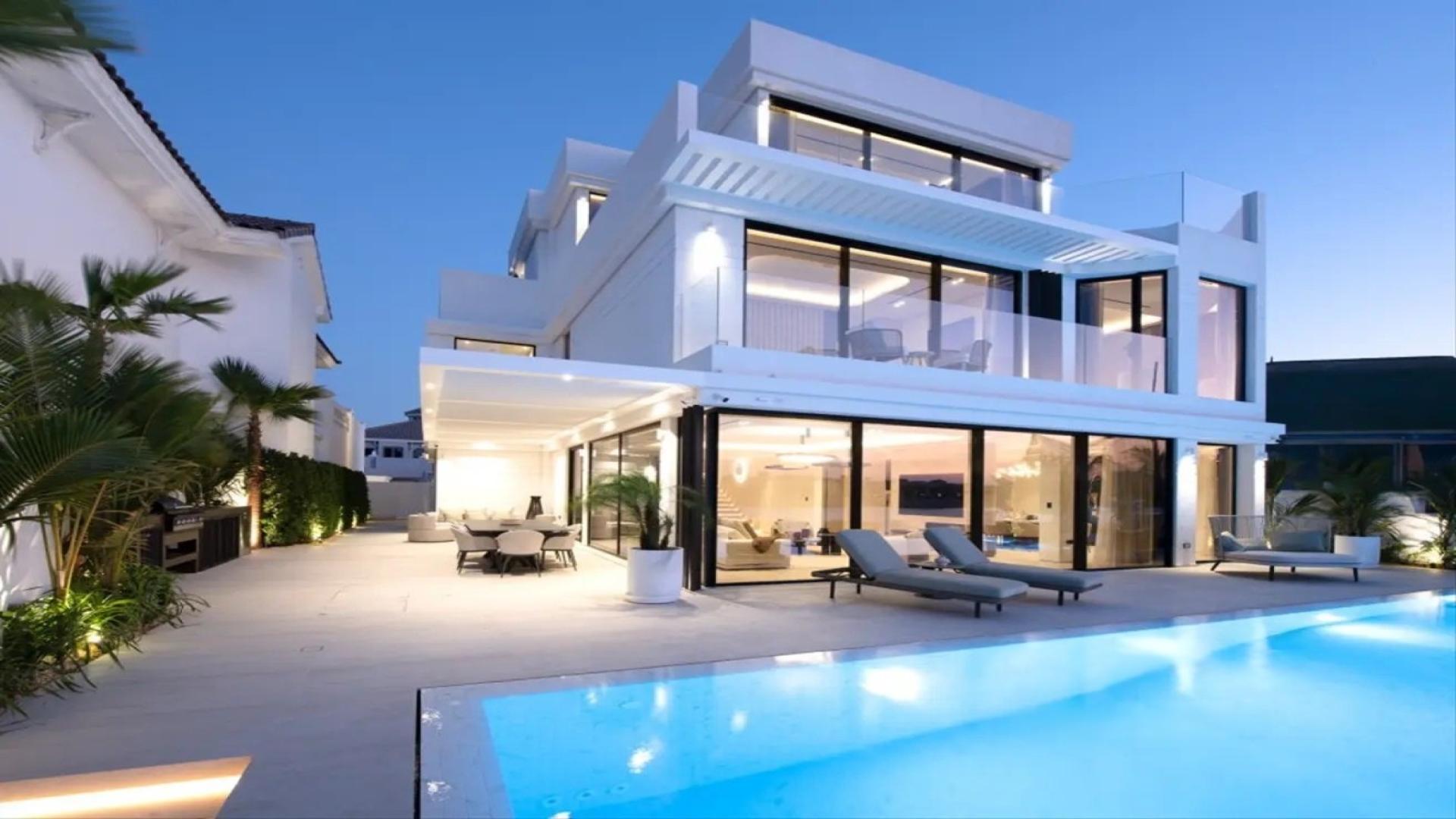 Luxurious modern villa exterior at dusk, Palm Jumeirah Garden Homes, for sale