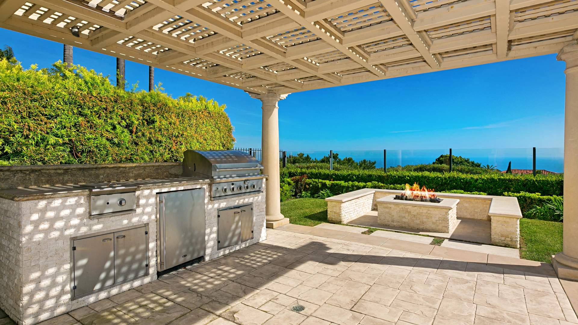 Luxurious bedroom with ocean views, elegant drapes, and chandelier in Pelican Hills villa