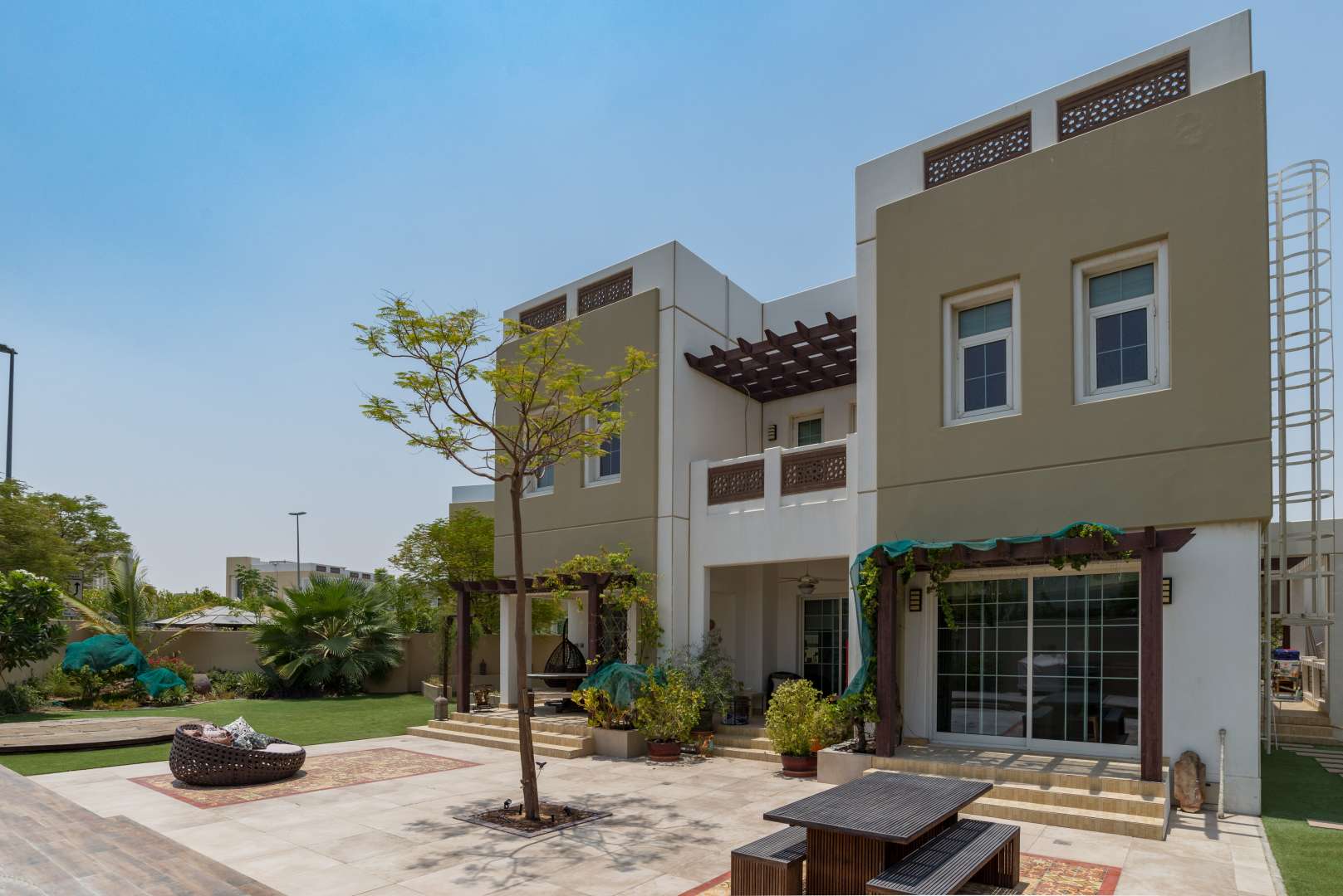 Modern 5-bedroom villa exterior in Rahat, Mudon community, featuring lush landscaping