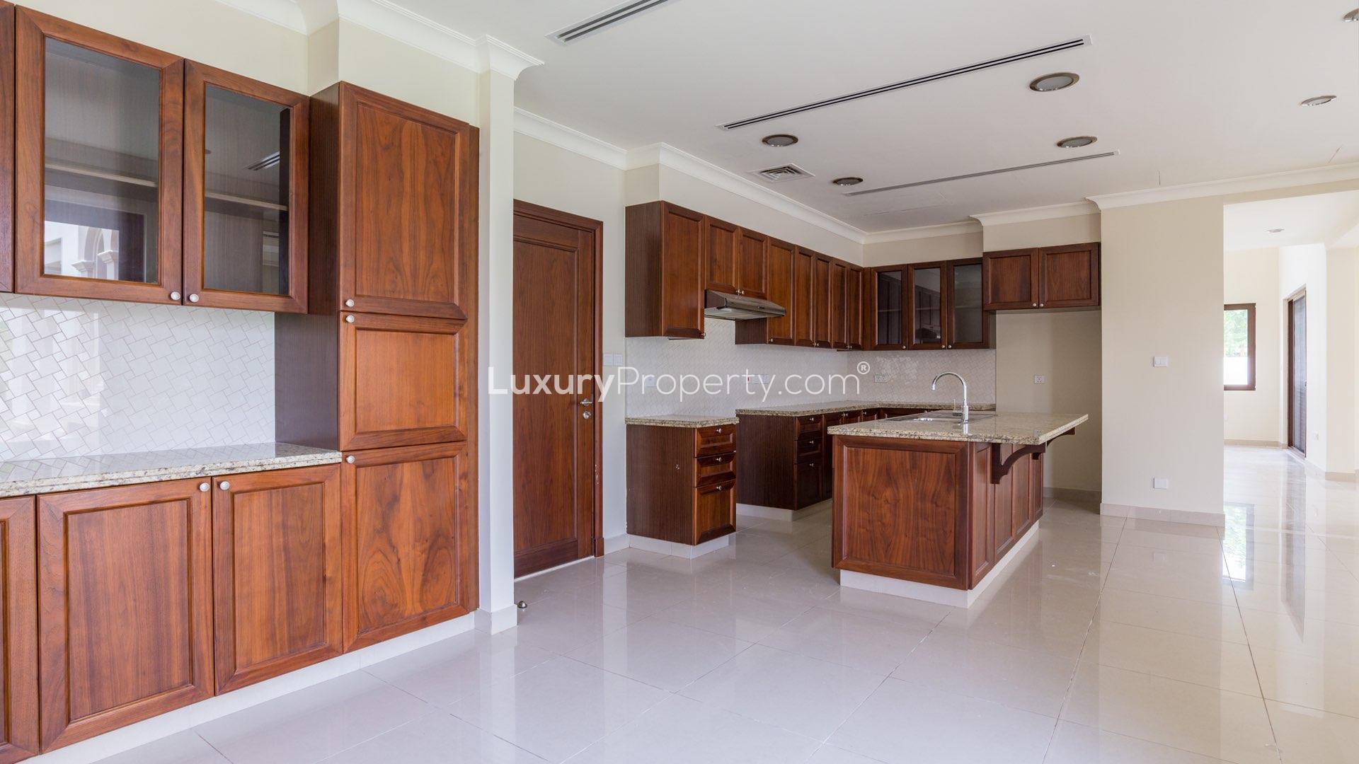 Spacious kitchen in 5-bedroom villa, Rosa, Arabian Ranches 2, with wooden cabinets and island
