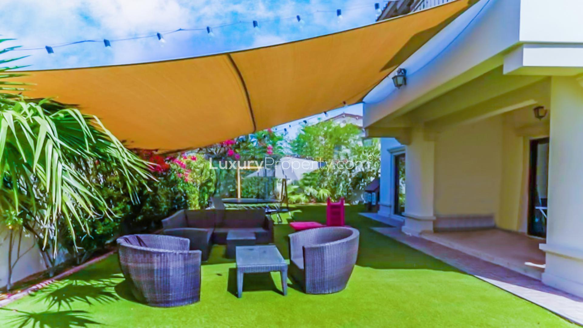 "Spacious backyard of Type 4 Rosa Villa in Arabian Ranches 2 with green lawn and swing.",Outdoor patio area of Type 4 Rosa Villa in Arabian Ranches 2, Dubai