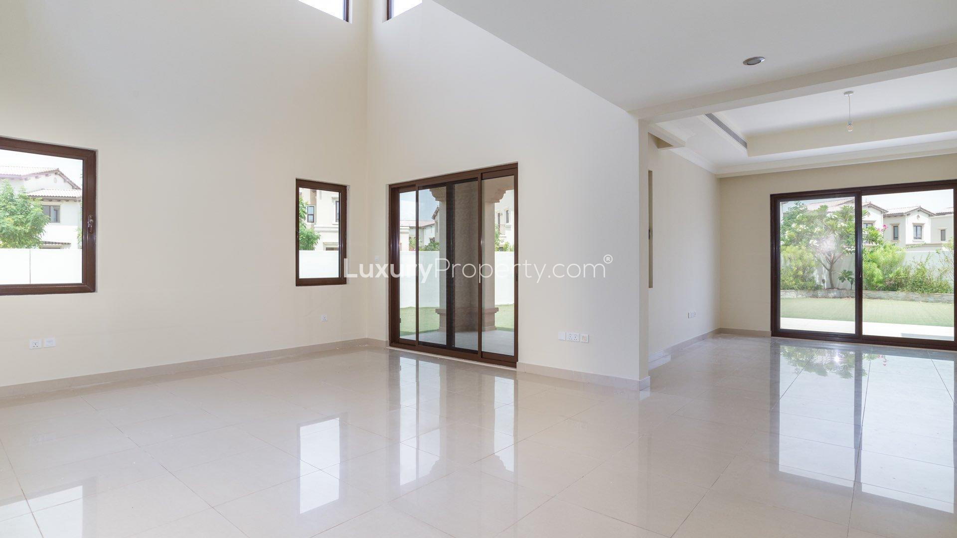 Elegant villa interior with large glass doors opening to garden in Rosa, Arabian Ranches 2