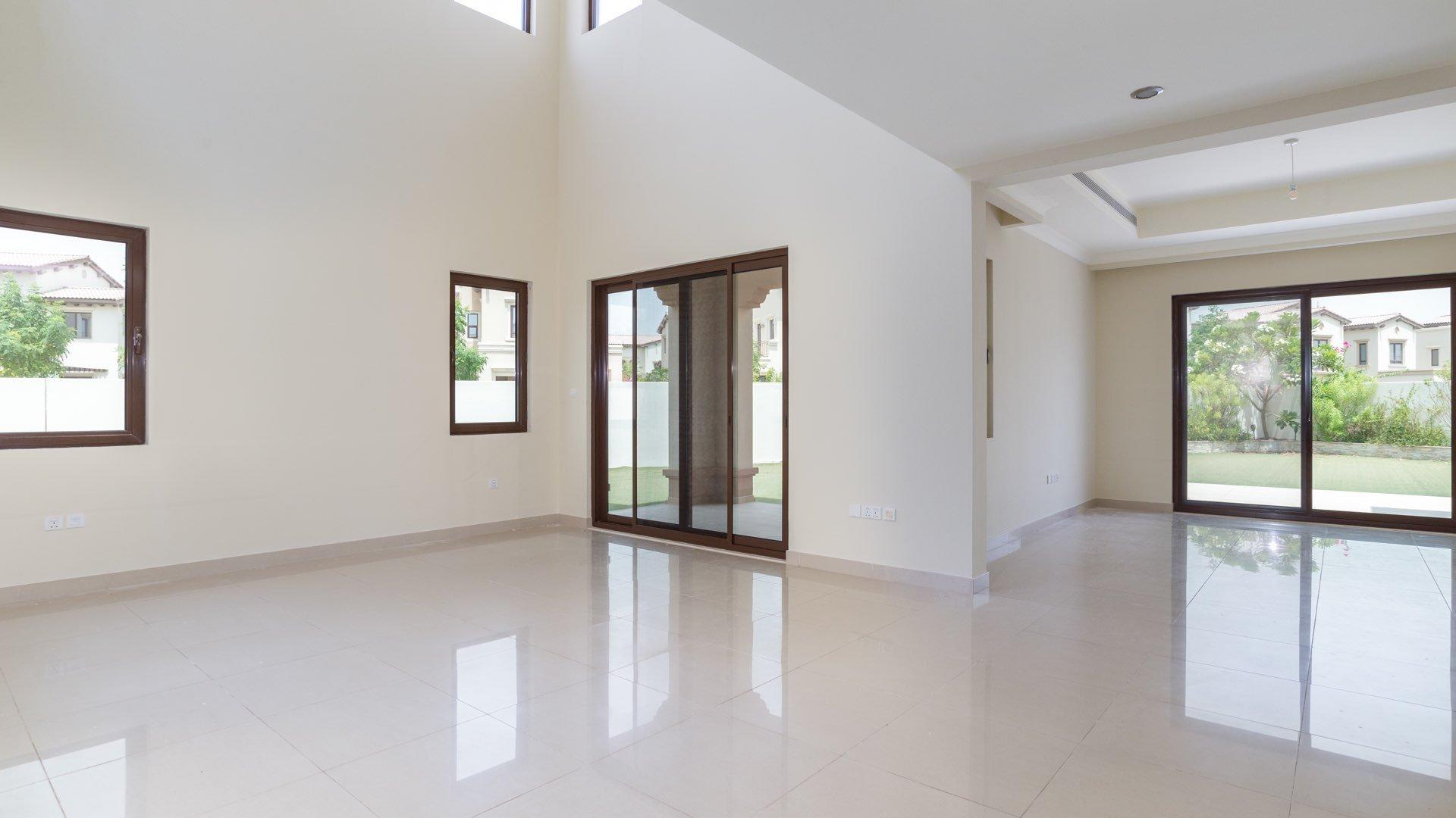 Elegant villa interior with large glass doors opening to garden in Rosa, Arabian Ranches 2